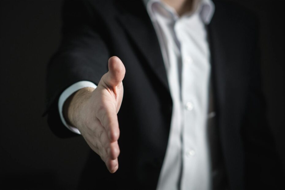 Man in a suit holding out his hand for a handshake