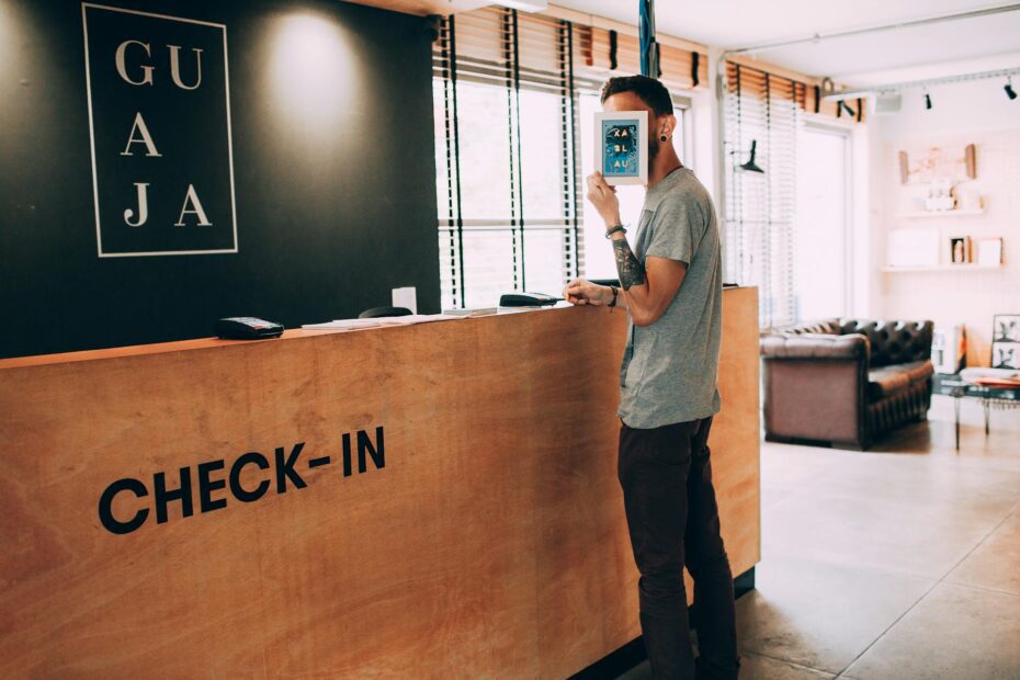 A man hiding his face at a reception desk.